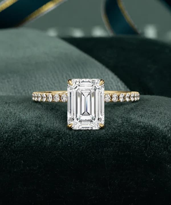 Emerald cut engagement ring in yellow gold on green velvet