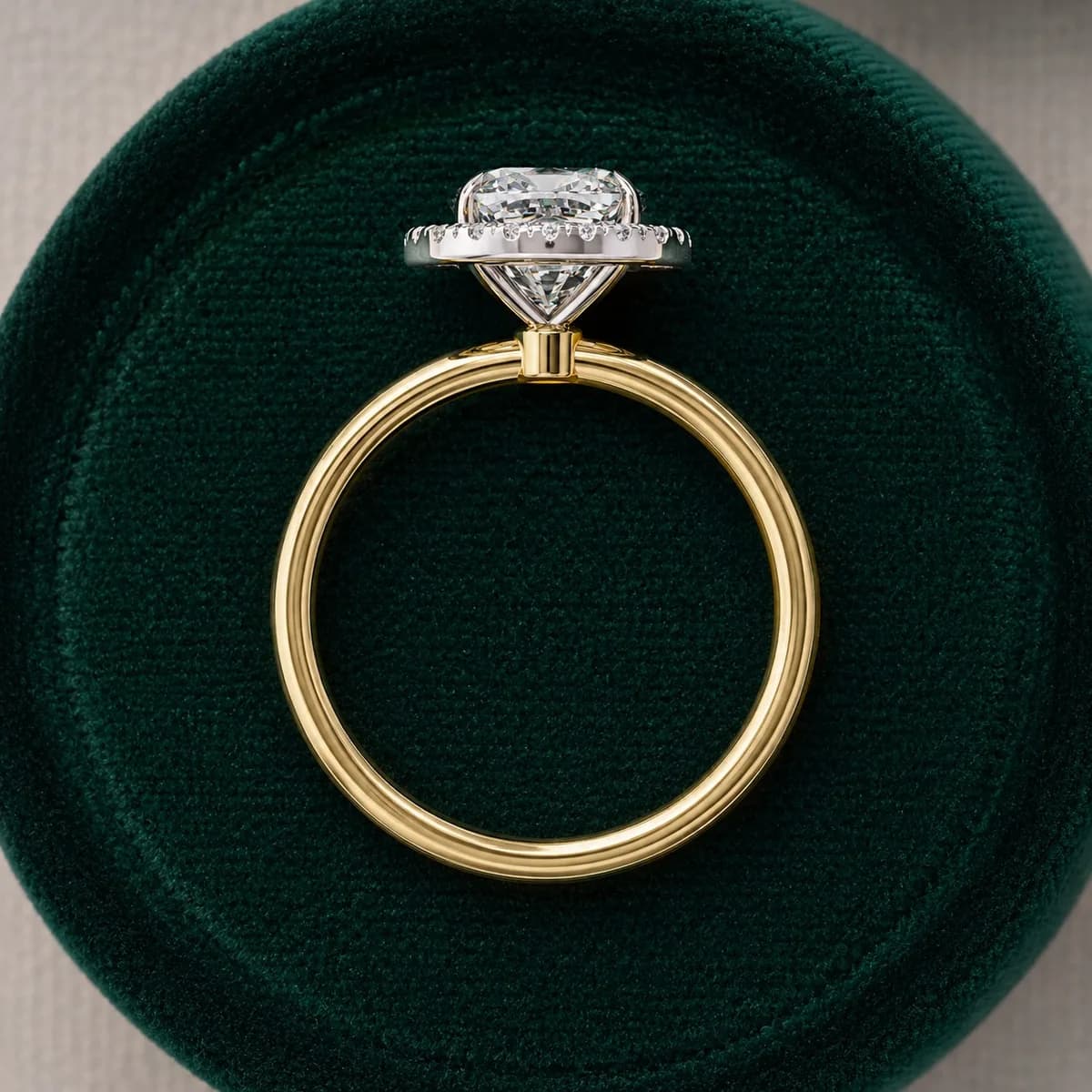 Cushion cut lab grown diamond halo engagement ring in yellow gold in a green velvet ring box
