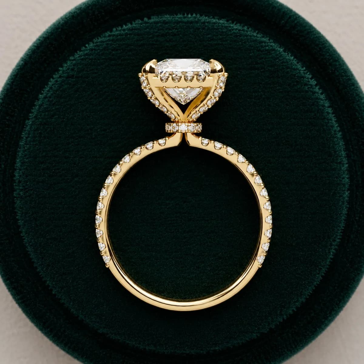 Princess cut lab grown diamond halo engagement ring in yellow gold in a green velvet ring box