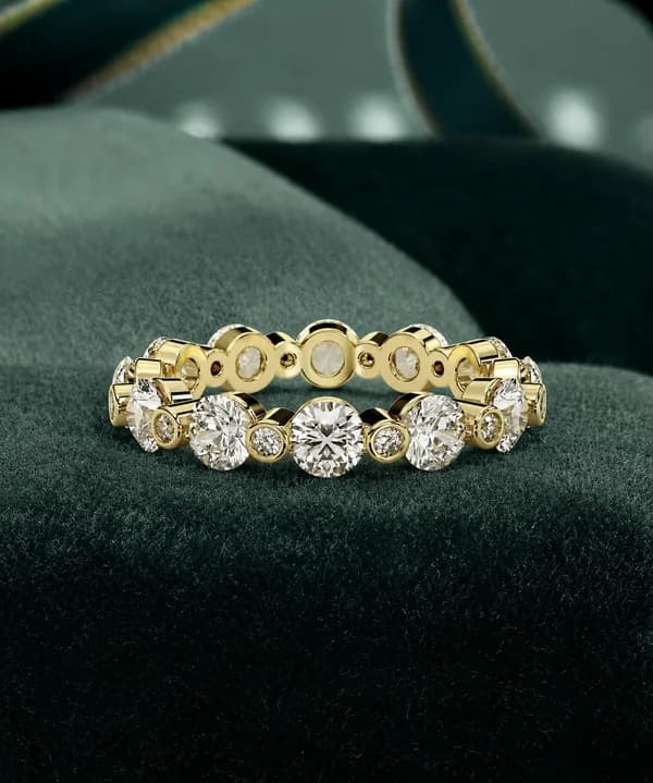 Round lab grown diamond alternating full eternity band in yellow gold on green velvet