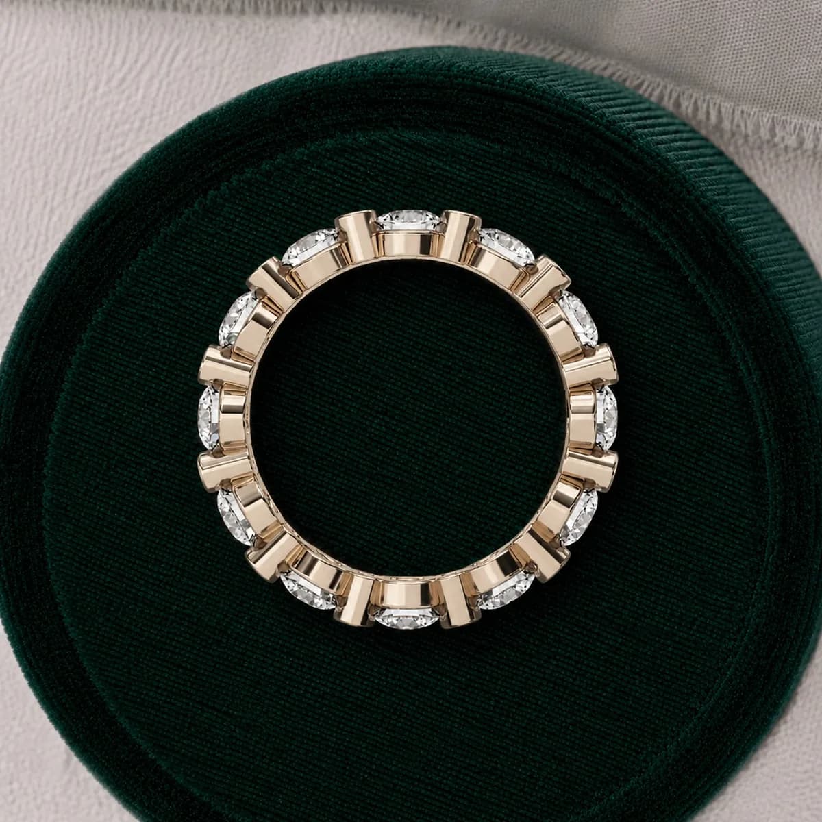 Round lab grown diamond alternating full eternity band in yellow gold in a green velvet ring box