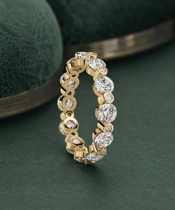Round lab grown diamond alternating full eternity band in yellow gold on green velvet