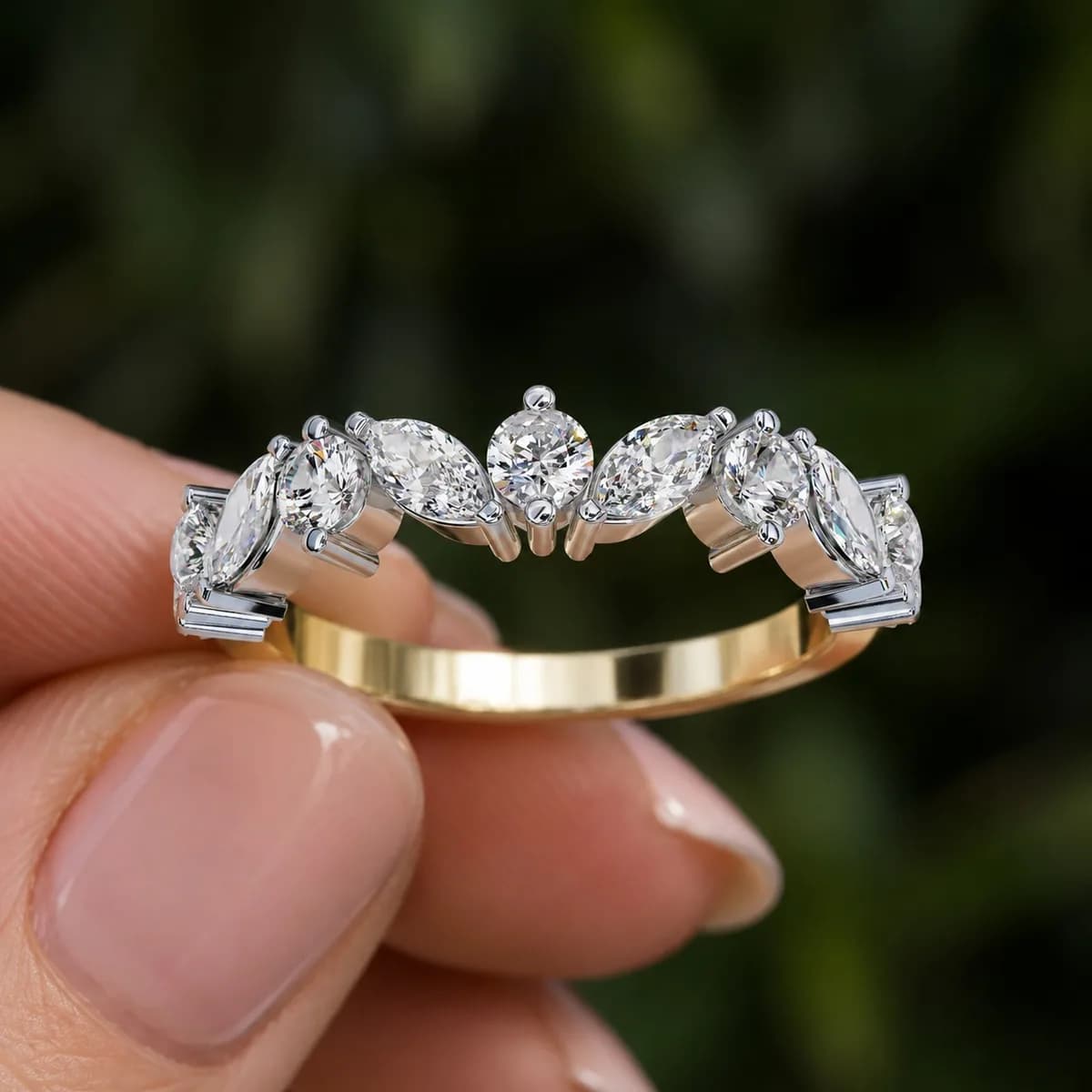 Marquise and round lab grown diamond curved contour wedding band in yellow gold held between fingertips