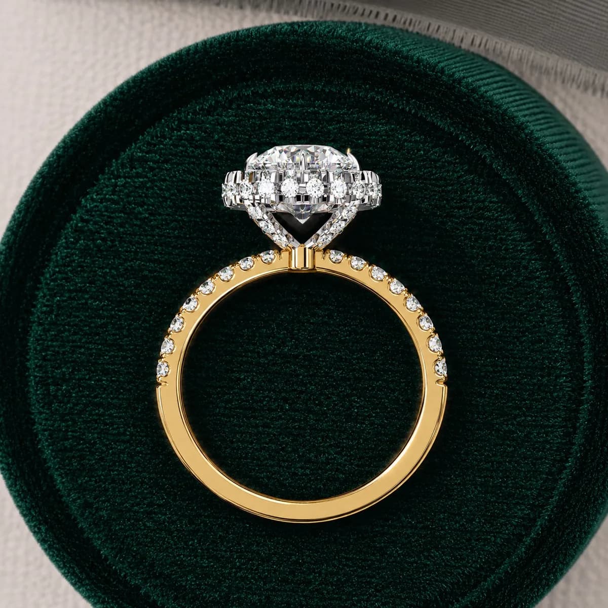 Round lab grown diamond halo engagement ring in yellow gold in a green velvet ring box