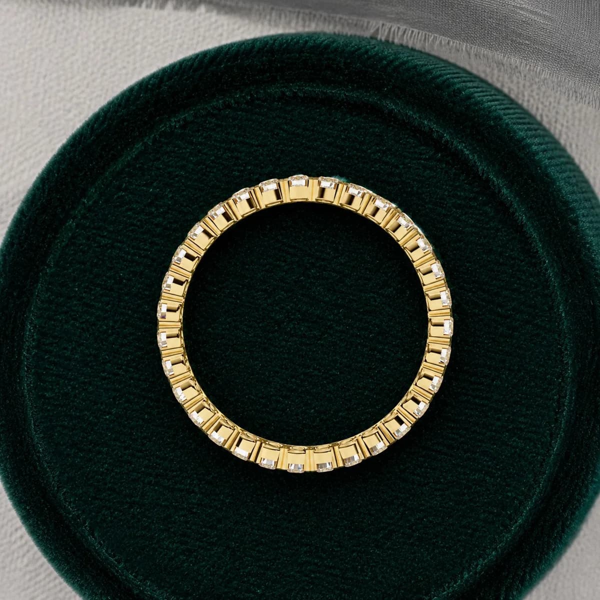 Round lab grown diamond full eternity wedding band in yellow gold standing in a green velvet ring box