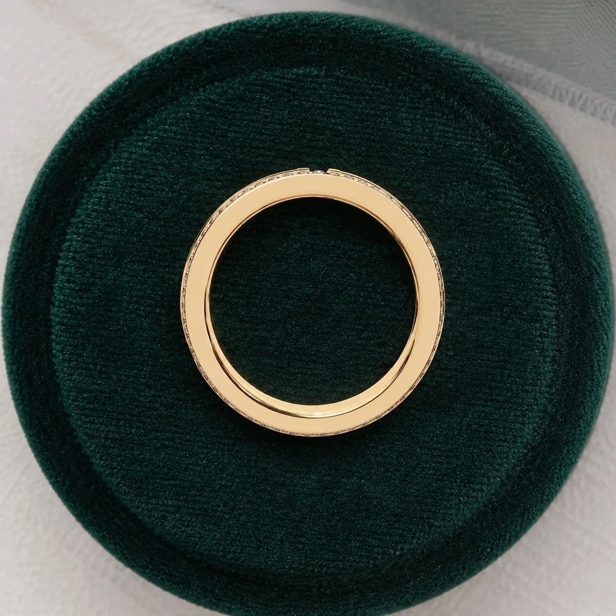 Wide four-row pavé lab grown diamond eternity band in yellow gold standing in a green velvet ring box