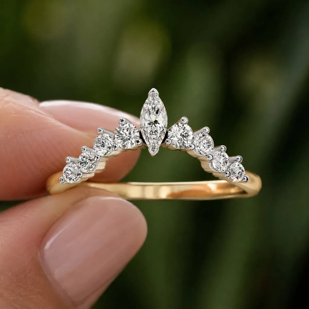 Curved lab grown diamond crown wedding band in yellow gold held between fingertips