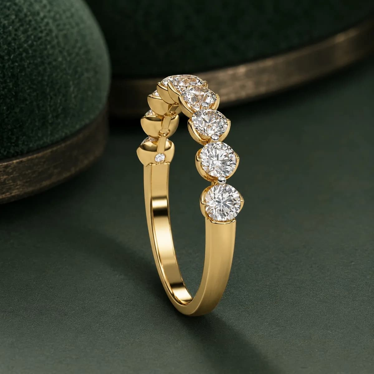 Round lab grown diamond half eternity wedding band in yellow gold standing upright on green velvet, side view
