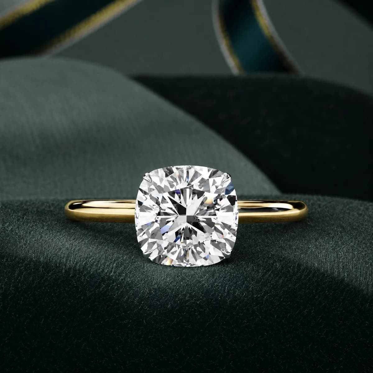 Cushion cut lab grown diamond hidden halo solitaire in yellow gold resting on green velvet