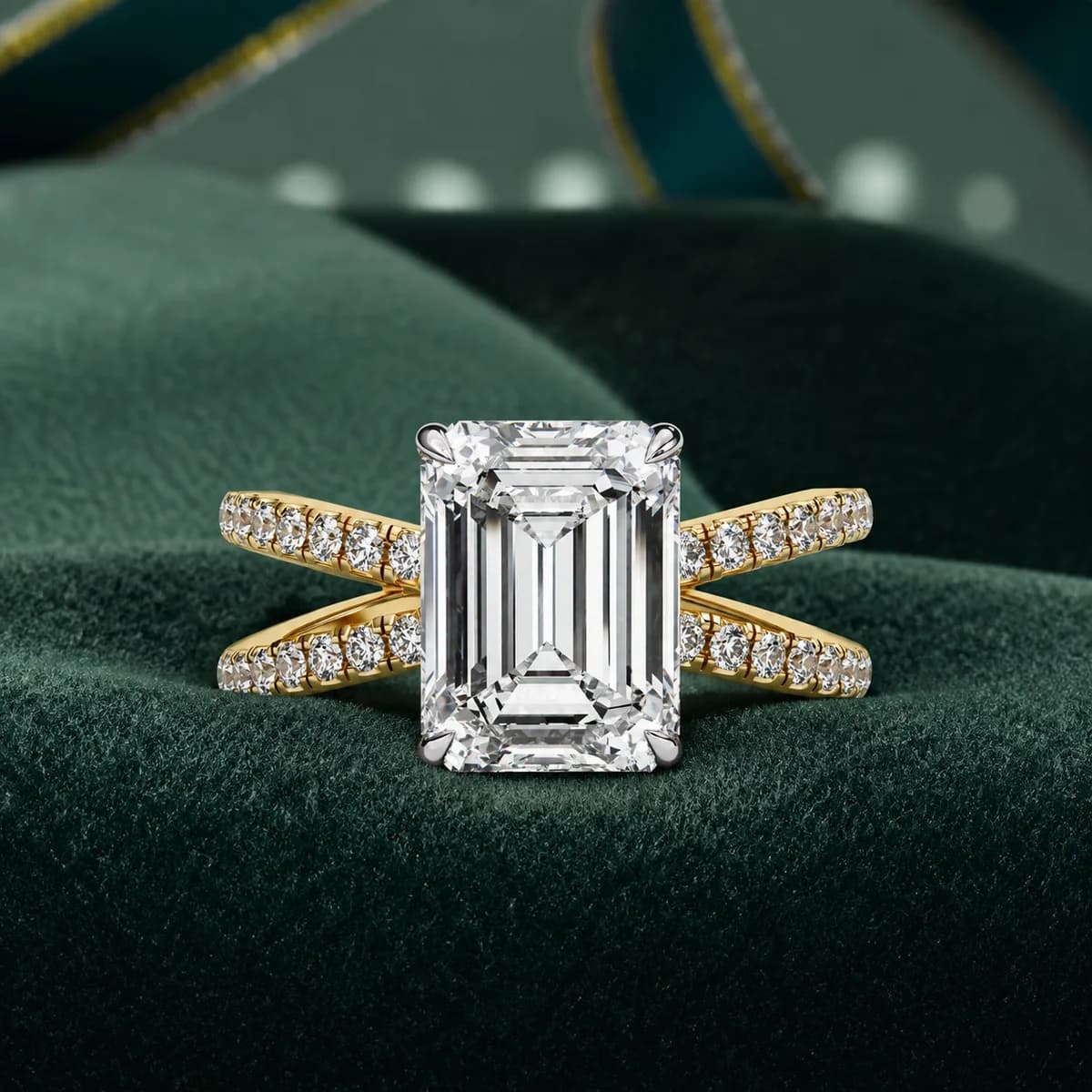 Emerald cut lab grown diamond criss-cross split shank engagement ring in yellow gold on green velvet