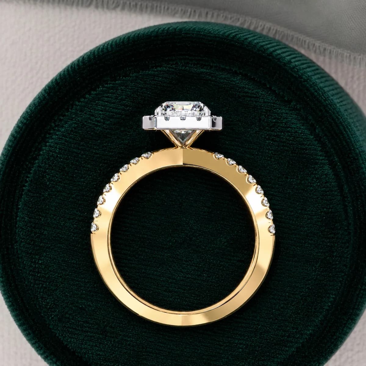 Radiant cut lab grown diamond halo split shank engagement ring in yellow gold standing in a green velvet ring box