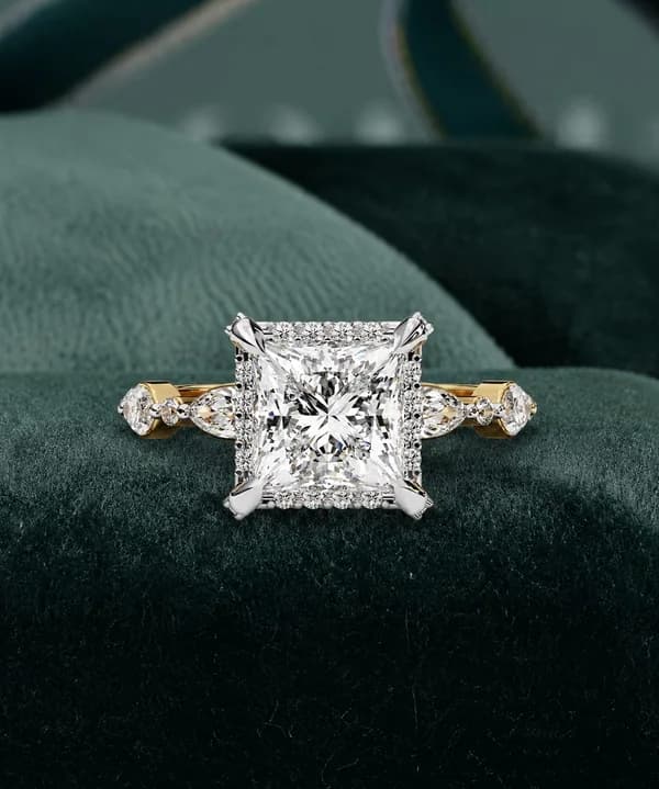 Princess cut lab grown diamond halo engagement ring with marquise side stones in yellow gold on green velvet