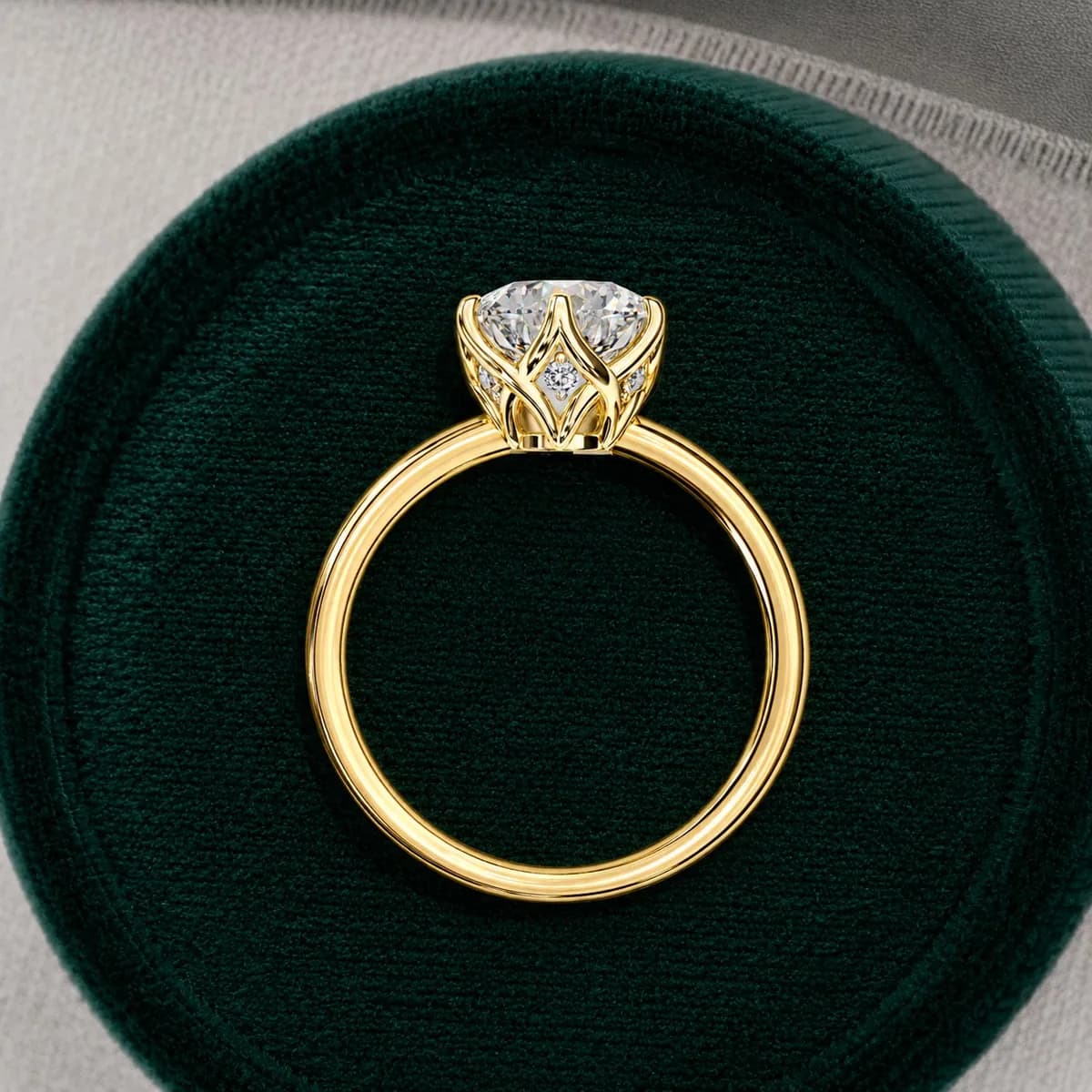 Round lab grown diamond six-claw tulip basket solitaire engagement ring in yellow gold standing in a green velvet ring box