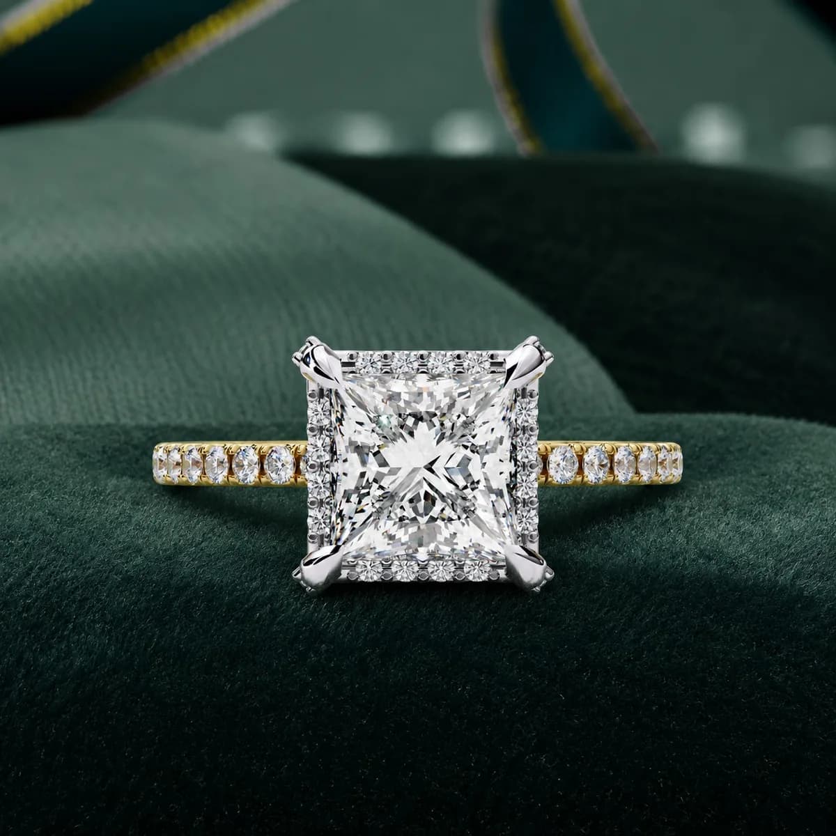 Princess cut lab grown diamond halo pavé engagement ring in yellow gold resting on green velvet