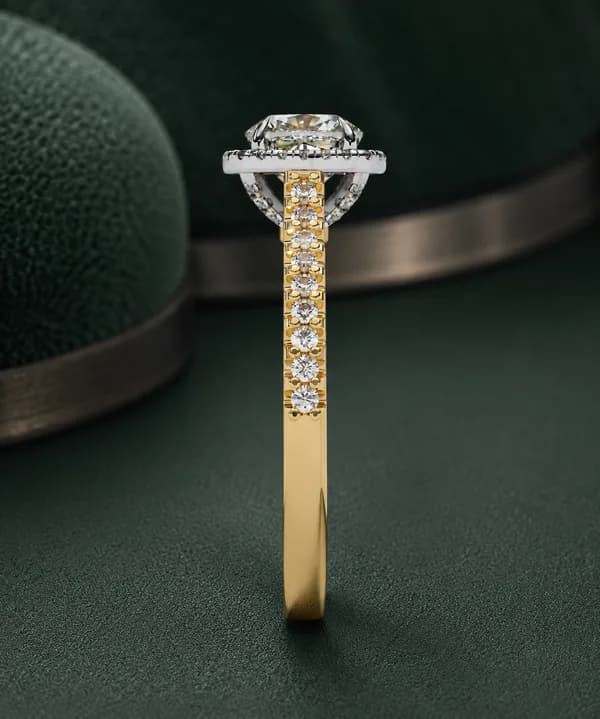Cushion cut lab grown diamond halo pavé engagement ring in yellow gold on green velvet