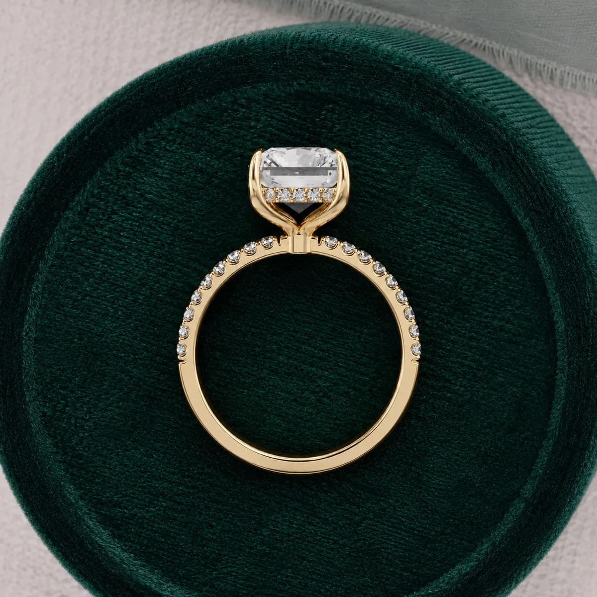Radiant cut lab grown diamond hidden halo pavé engagement ring in yellow gold in a green velvet ring box
