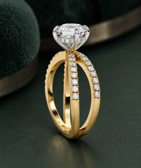 Round lab grown diamond criss-cross pavé engagement ring in yellow gold, side view on green velvet