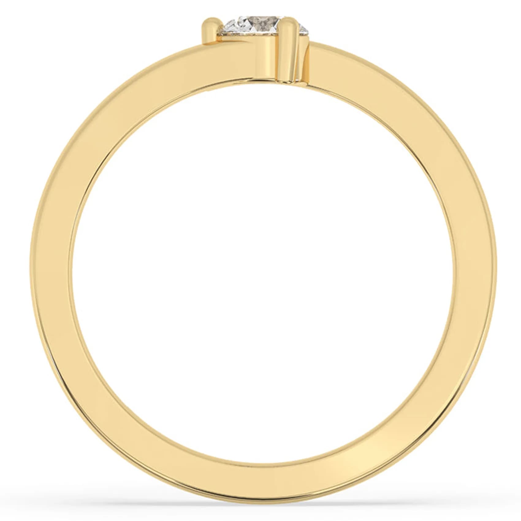 Through-finger view of the bypass solitaire ring in yellow gold, showing the crossing band ends